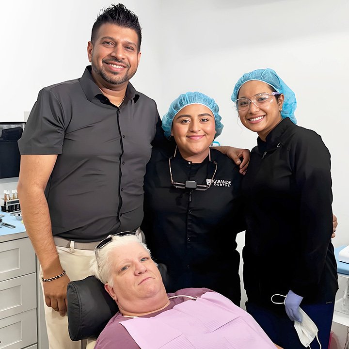 Dr. Sachin Karande standing with his dental team and a happy patient after successful treatment at Karande Dental Care