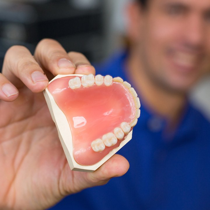 Dentist displaying a removable denture in Stafford, VA